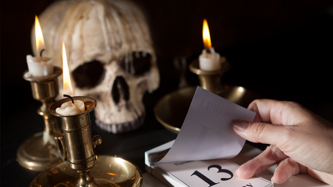 Inszeniertes Bild mit Totenkopf, Kerze, Kalender mit Freitag, 13.