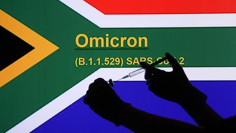 Symbolbild: Vor der Flagge Südafrikas wird eine Spritze aufgezogen