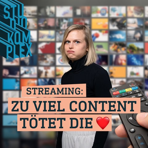 Unsere Hostin Anne schaut überfordert in die Kamera, sie hat die Qual der Wahl im Streaming Angebot. Im Hintergrund ist eine ganze Wand an Bildschirmen, die unterschiedliche Filme zeigt. Im rechten Vordergrund sieht man eine Fernbedienung, die gerade bedient wird.