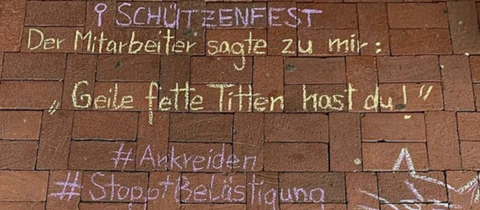 Kreide-Aufschrift auf einer Straße: "Schützenfest. Der Mitarbeiter sagte zu mir: Geile, fette Titten hast Du"