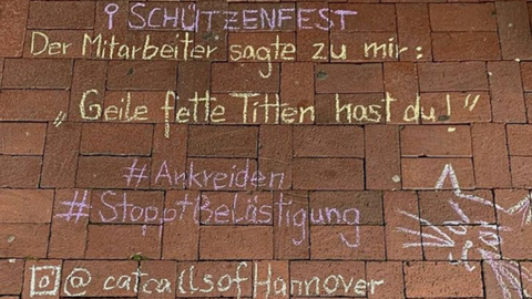 Kreide-Aufschrift auf einer Straße: "Schützenfest. Der Mitarbeiter sagte zu mir: Geile, fette Titten hast Du"