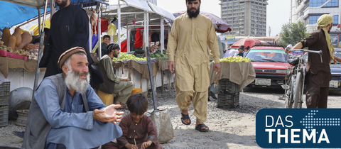 Ein Mann und ein Kind betteln in Kabul