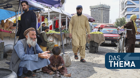 Ein Mann und ein Kind betteln in Kabul