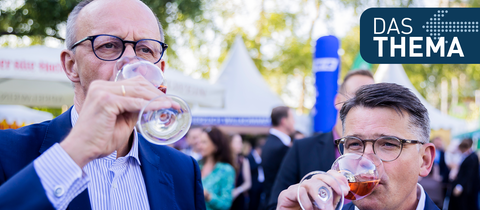 Boris Rhein (CDU, l), Ministerpräsident von Hessen, und Friedrich Merz, CDU-Bundesvorsitzender, trinken beim Hessenfest in der Hessischen Landesvertretung beim Bund Wein.