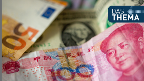 Eine Chinesische 100 Yuan-Banknote (vorne), ein 1 US-Dollar Geldschein (M) und eine 50-Euro-Banknote (l) liegen auf einem Tisch