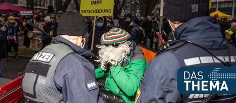 Polizisten sprechen mit einem Teilnehmer einer Demo gegen die Corona-Maßnahmen