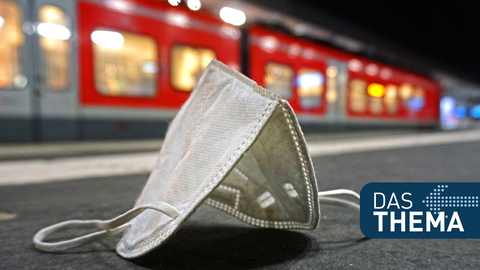 FFP2-Maske liegt an einem Bahnhof auf dem Boden