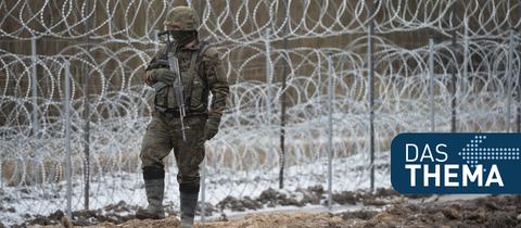 Ein polnischer Soldat patroulliert an der Grenze zu Belarus vor einem Stacheldrahtzaun.