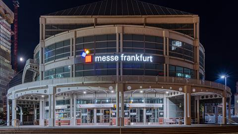 Der beleuchtete Haupteingang der Messe Frankfurt am Abend.