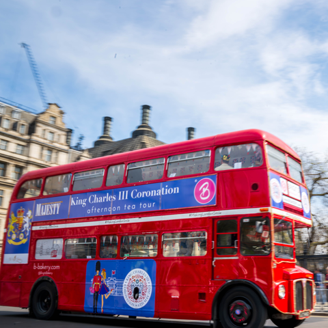 "King Charles Coronation" steht auf einem Doppeldeckerbus, der am Big Ben vorbei fährt