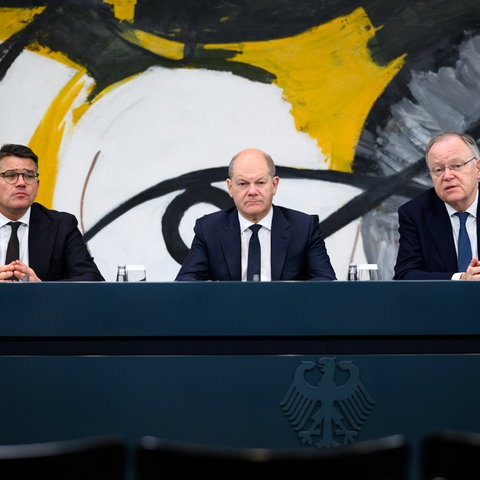 Bundeskanzler Olaf Scholz (M, SPD) äußert sich zusammen mit Boris Rhein (l, CDU), Ministerpräsident von Hessen, und Stephan Weil (SPD), Ministerpräsident von Niedersachsen, bei einer Pressekonferenz nach dem Bund-Länder-Gipfel im Bundeskanzleramt.