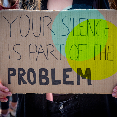 Ein Plakat mit der Aufschrift "YOUR SILENCE IS PART OF THE PROBLEM"