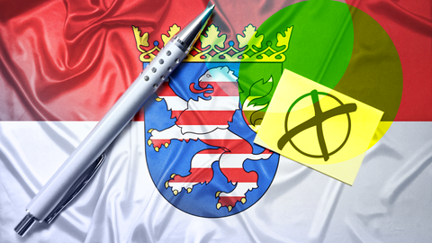 Fahne des deutschen Bundeslandes Hessen mit Zettel, Wahlkreuz und Kugelschreiber