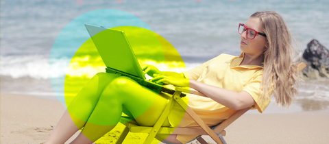Frau liegt mit Laptop im Liegestuhl am Strand