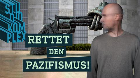 Der Host steht im Vordergrund und schaut zur Seite direkt in eine übergroße verknotete Pistole, die auf seinen Kopf gerichtet ist