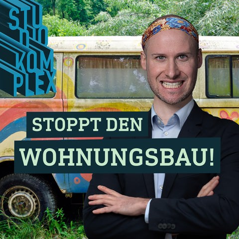 Der Host trägt ein seriös wirkendes Sakko und trägt eine bunte hippihafte Bandana auf dem Kopf. Er blickt mit breitem Grinsen in die Kamera. Im Hintergrund steht ein alter laienhaft bunt bemalter VW-Bus im Grünen