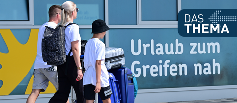 Urlauber gehen zum Terminal des Kassel-Airports. 