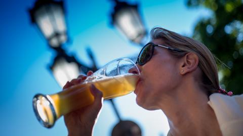 Frau trinkt an einem Glas Bier