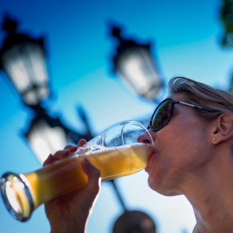 Frau trinkt an einem Glas Bier