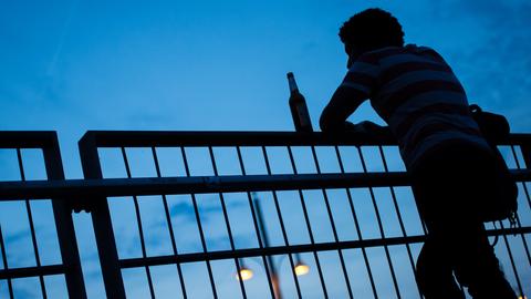 Silhouette eines Manns mit einer Flasche Bier