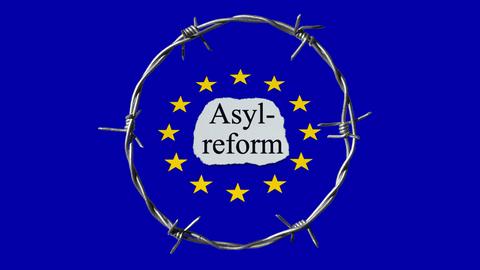 EU-Fahne, in der Mitte steht "Asylreform", darum ein Kreis aus Stacheldraht 