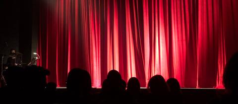 roter Vorhang vor einer Theaterbühne