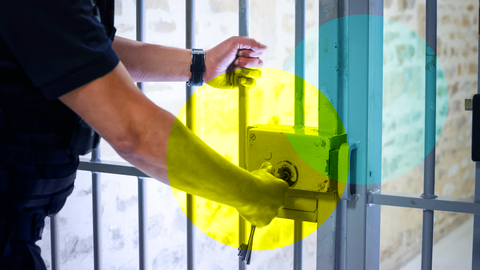 Wärter in einem Gefängnis schließt eine Gittertür ab