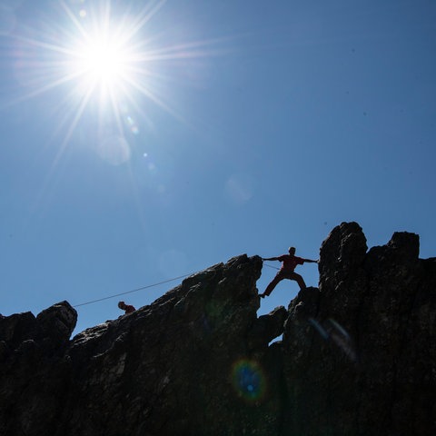 An den Eschbacher Klippen trainieren Kletterer vor einem strahlend blauem Himmel. 