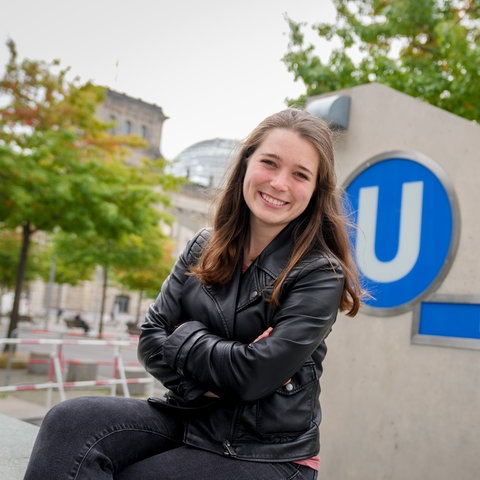 Emilia Fester sitzt vor der U-Bahn-Haltestelle des Bundestags