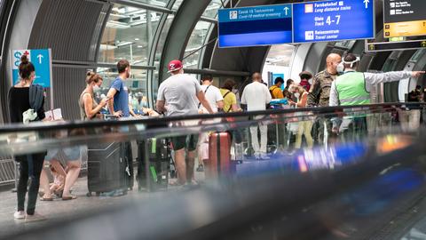 Passagiere warten am Flughafen Frankfurt in einer langen Schlange