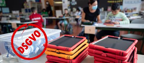 Klassenzimmer mit Kindern und Lehrerin im Hintergrund. Vorne liegen auf einem tisch Tablets in roten Hüllen. Auf dem Bild ist ein roter Stempel, der DSGVO in einem Kreis zeigt.