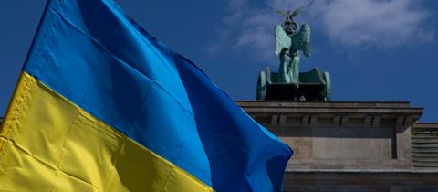 Die Fahne der Ukraine weht bei einer Protestaktion gegen den russischen Krieg in der Ukraine am Brandenburger Tor. 