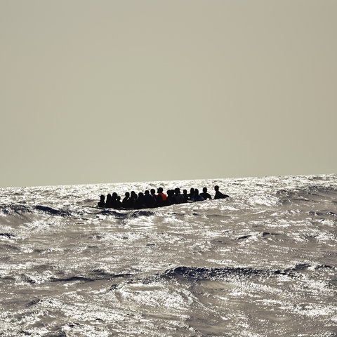 in Holzboot mit etwa 30 Menschen versucht bei hohen Wellengang die gefährliche Überfahrt nach Italien