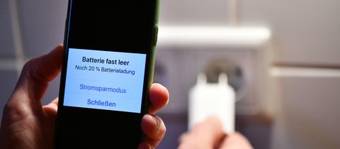 Smartphone auf dessen Display die Meldung steht, dass die Batterie fast leer ist