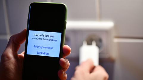 Smartphone auf dessen Display die Meldung steht, dass die Batterie fast leer ist
