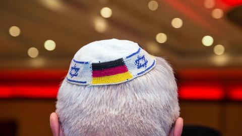 Ein Mann trägt eine Kippa mit israelischer und deutscher Flagge