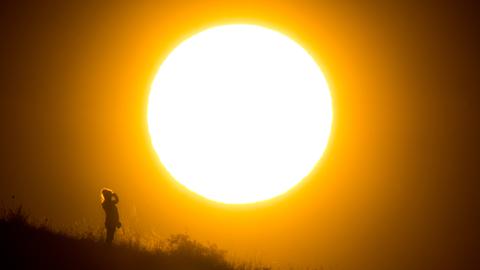 Frau vor untergehender Sonne