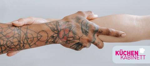 Zwei Hände umfassen gegenseitig ihre Handgelenke