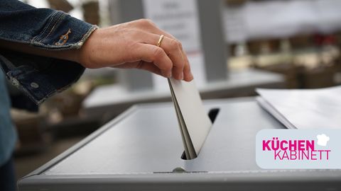 Ein Stimmzettel wird in eine Wahlrune gesteckt