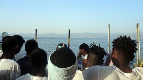 Migranten blicken auf die italienische Küste