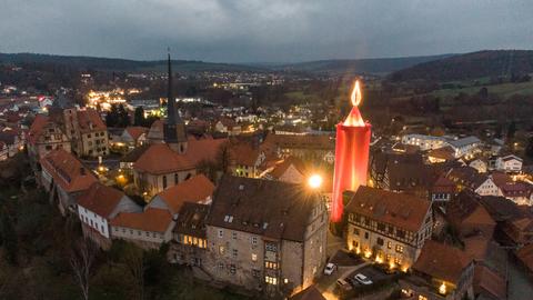Die „größte Adventskerze der Welt“ leuchtet über der Altstadt von Schlitz. Traditionell wird dazu ein 35 Meter hoher Turm zur Adventszeit rot verhüllt.
