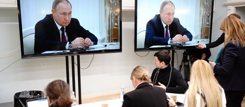 Journalisten verfolgen in einem Presseraum die Übertragung des Treffens von Bundeskanzler Olaf Scholz und Russlands Präsident Wladimir Putin.
