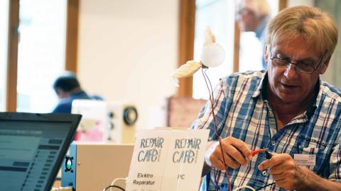 Mann in einem Repair-Café repariert Elektrogeräte