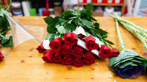 Rote Rosen liegen auf einem Tisch im Blumenladen