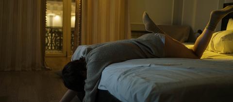 Person liegt schlaflos im Bett