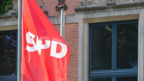 Rote SPD-Fahne weht an Fahnenmast vor Gebäude