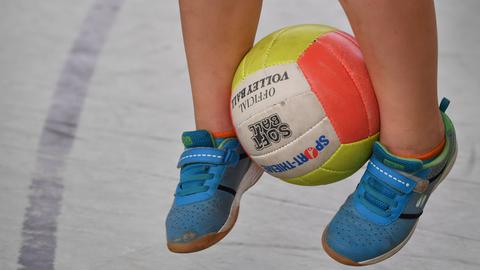 Kind hüpft mit einem Ball zwischen den Füßen