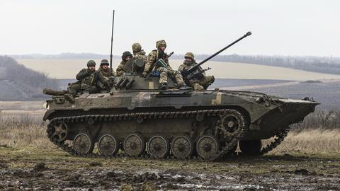 Ukrainische Soldaten sitzen während eines Militärtrainings auf einem sogenannten APC, einem gepanzerte Mannschaftstransportwagen.
